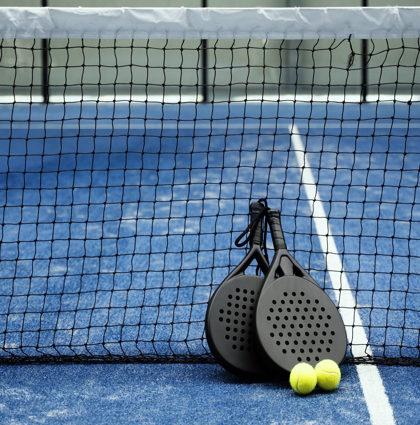 Padel-Tennisplatz mit Ball und Schlägern