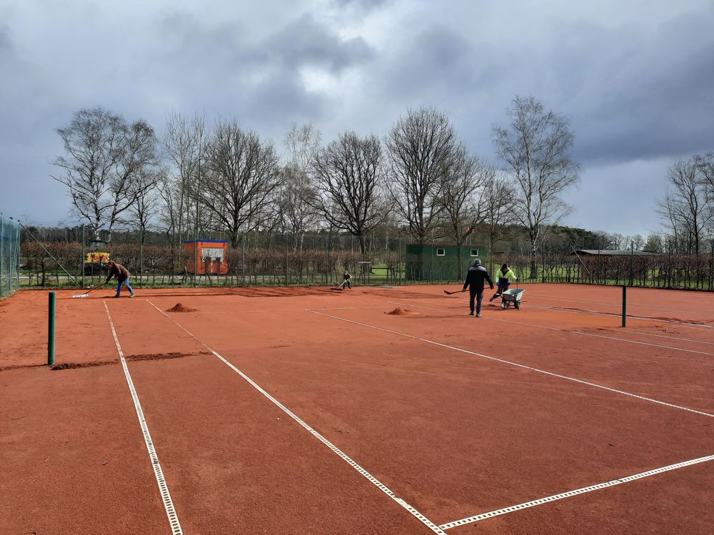 Mitglieder bereiten den Tennisplatz auf